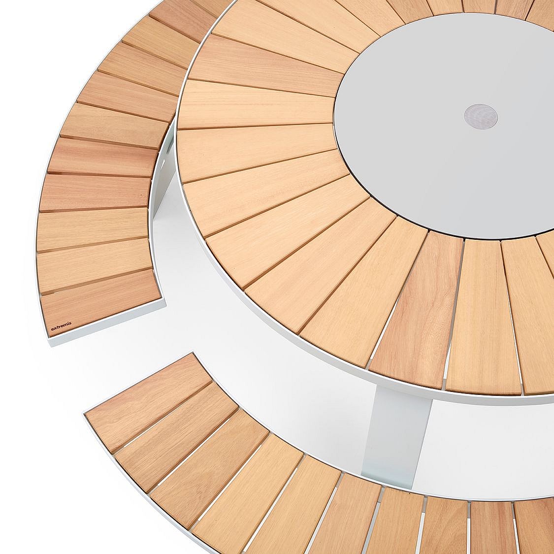 Vue de dessus d’une table ronde extérieure avec des lattes radiales en bois et deux bancs courbes assortis sur un fond clair.