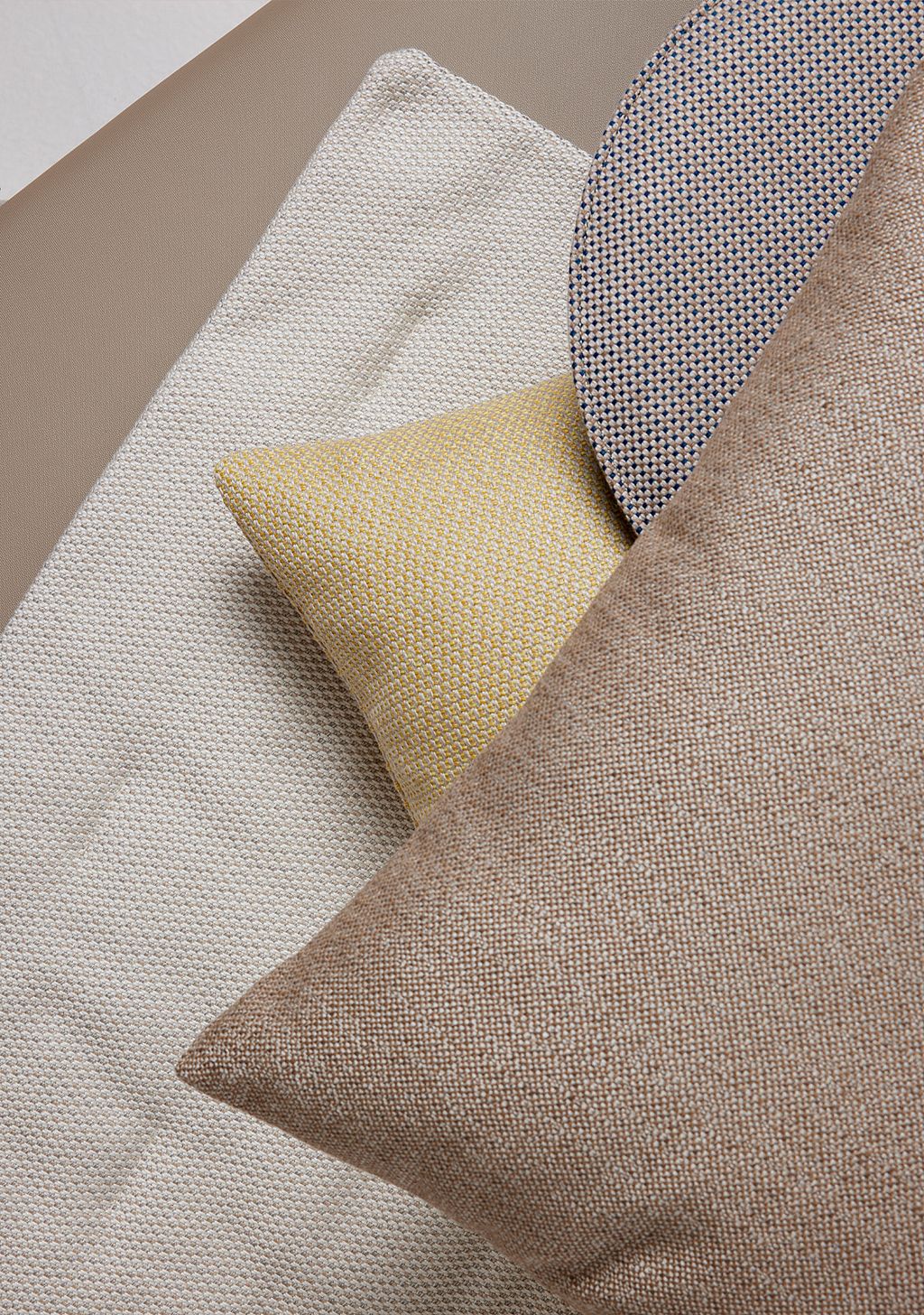 Close-up van geweven kussens in beige, gele en blauwpatroon stof.