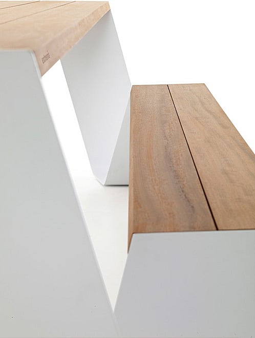   Gros plan d'une assise ou d'un plateau de table en métal couleur rouille, avec le nom Extremis discrètement embossé près de deux petits trous ronds.