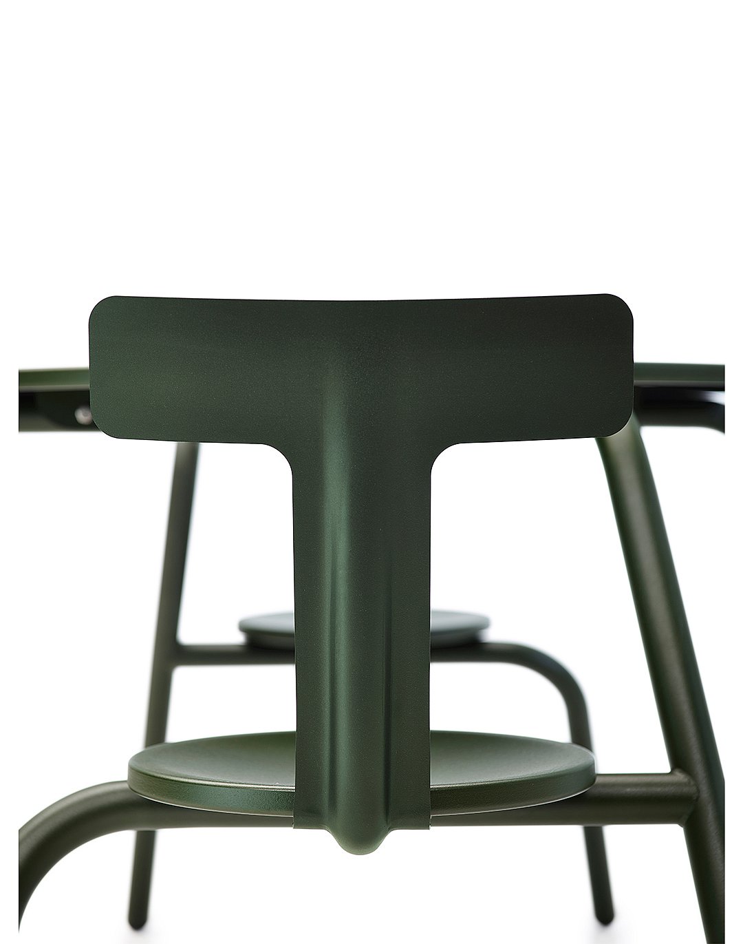 Gros plan avant d’une table Virus vert foncé montrant le support en forme de T sous la table, avec les sièges attachés et les pieds inclinés visibles derrière.