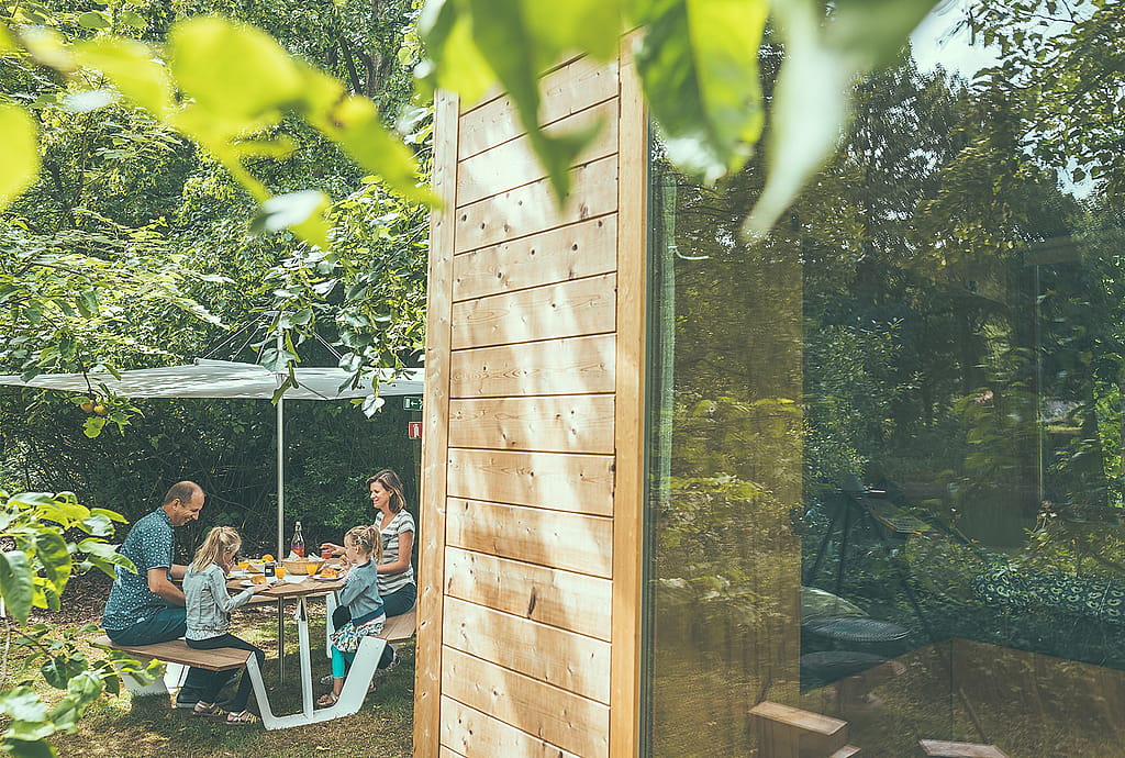 Een ander uitzicht op de Anker-picknicktafel met Inumbra-parasol, wat de beschutte eetgelegenheid in de buitenlucht versterkt.