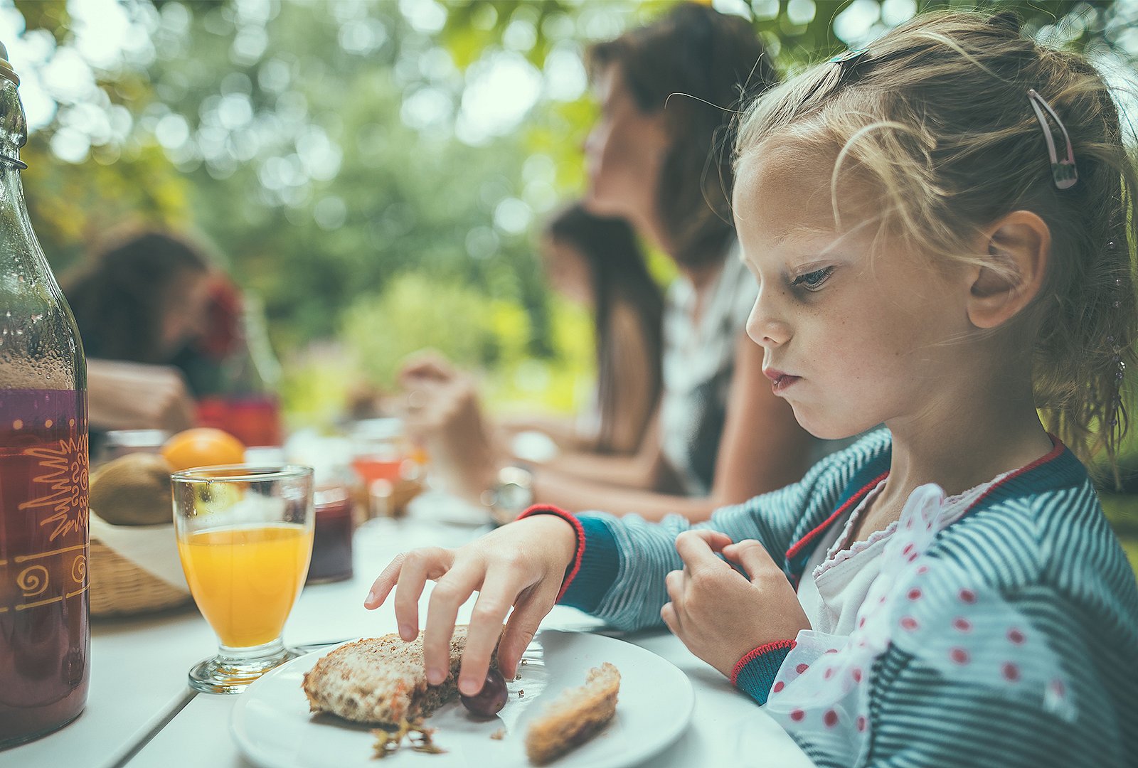 Kind aan de picknicktafel in de jachthaven tijdens een buitenontbijt, met aandacht voor familie-samenhorigheid in het Pop-Up Hotel.