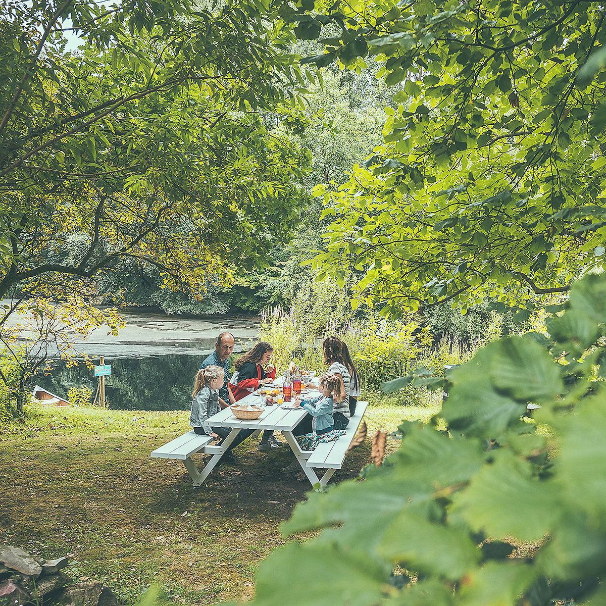 Klein huisje in glampingstijl in een bosrijke omgeving met Extremis-buitenmeubels in de buurt, die het verhaal introduceren van het vinden van rust en saamhorigheid in de natuur.