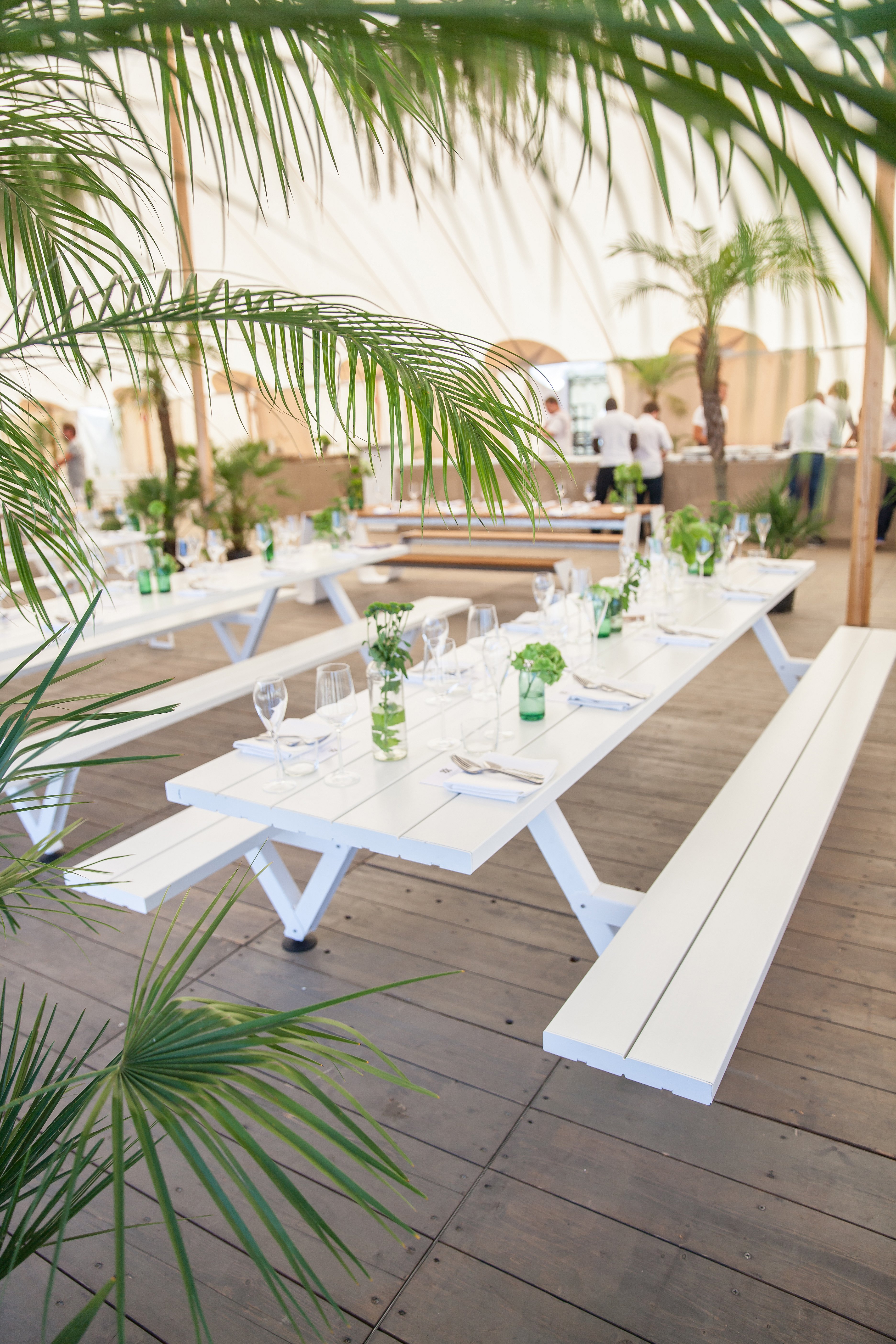 Tables de pique-nique Marina blanches disposées pour un repas sur une terrasse en bois