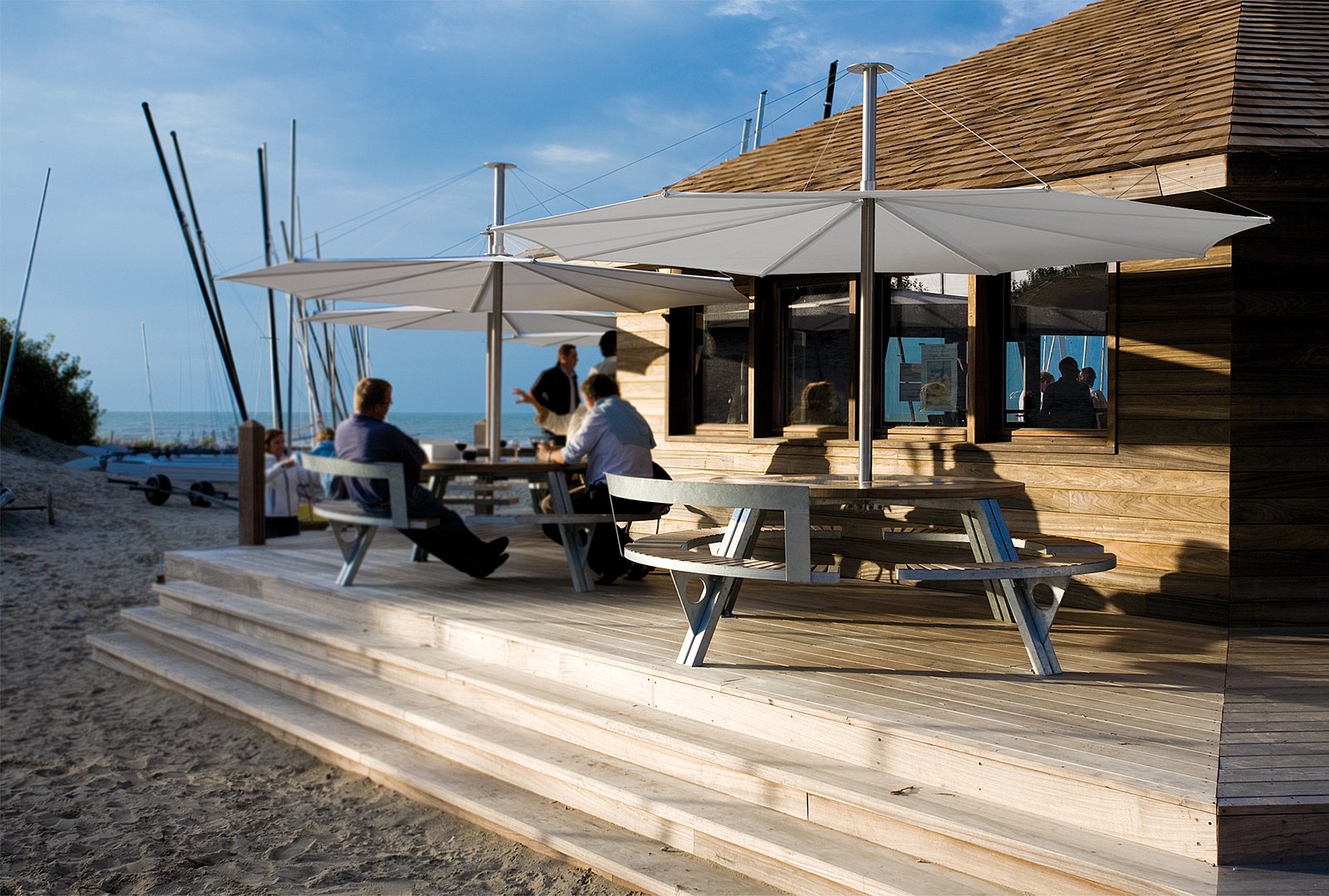 Uitzicht op de gargantua-tafels op de surferplaats in Oostduinkerke, waardoor het comfortabel is voor surfers en mensen in een rolstoel. Ze zijn ook goed beschermd tegen de zon vanwege de inumbra-tinten die ze bedekken.
