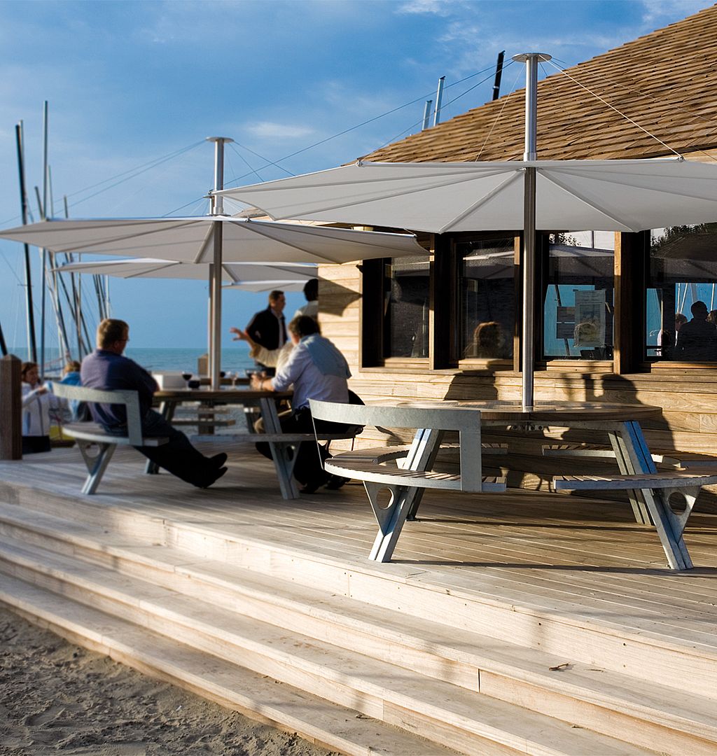 Uitzicht op de gargantua-tafels op de surferplaats in Oostduinkerke, waardoor het comfortabel is voor surfers en mensen in een rolstoel. Ze zijn ook goed beschermd tegen de zon vanwege de inumbra-tinten die ze bedekken.