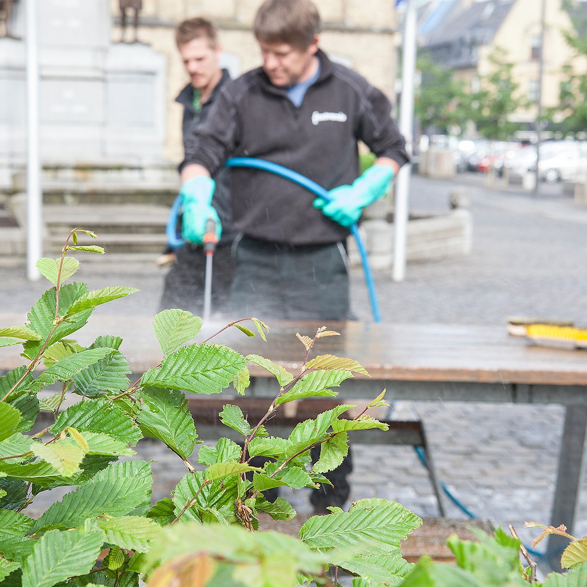 Verweerde houten hoptafel die buiten op een marktplein in Poperinge staat, getoond voor de voorjaarsschoonmaak.