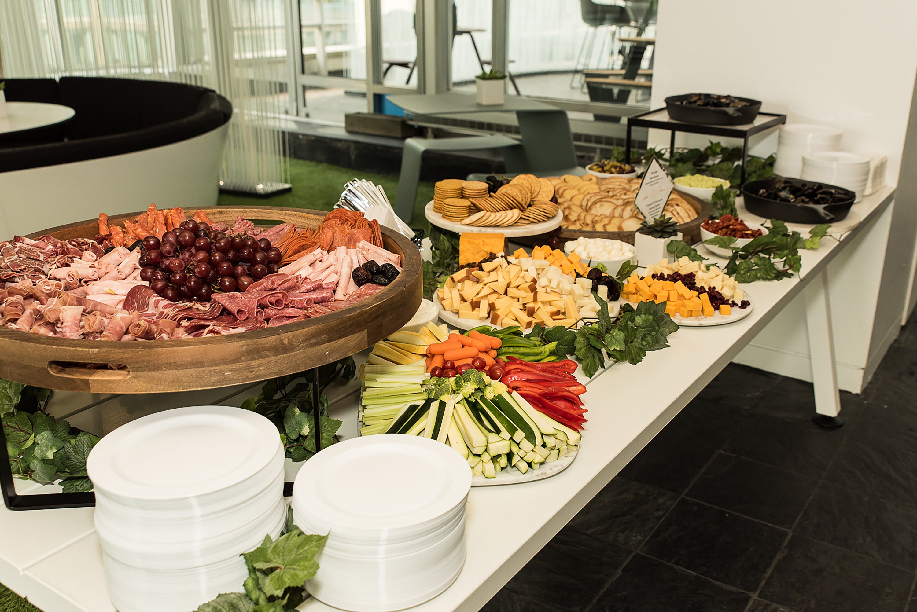 Grand buffet rempli de charcuteries, fromages, raisins, pain et légumes coupés, reflétant le thème culinaire belge de l’événement.