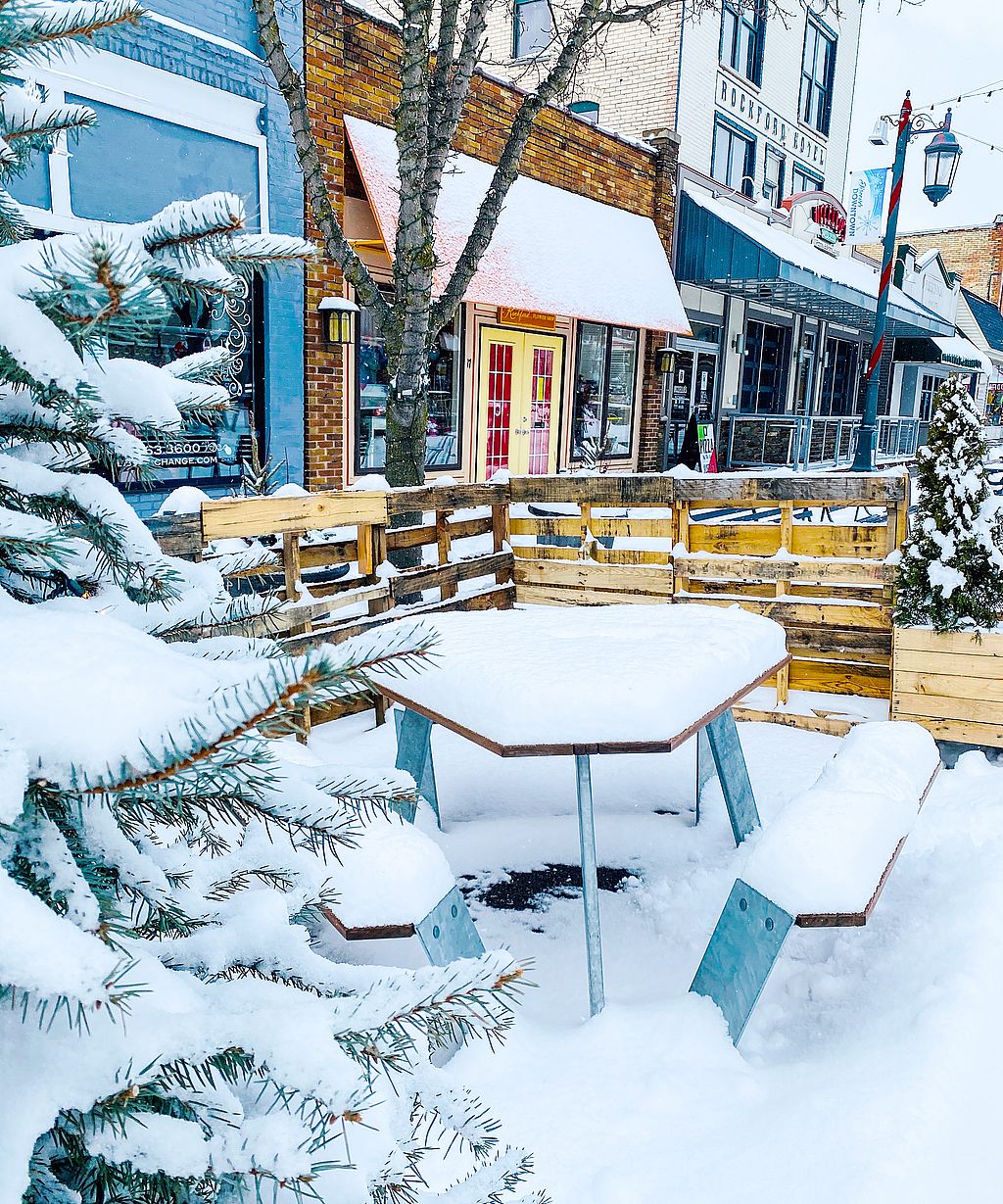 Der Winterblick auf die Hauptstraße von Rockford verwandelte sich in einen festlichen Treffpunkt für Fußgänger mit Sitzgelegenheiten im Freien, Feuerstellen, Lichterketten und Schnee.