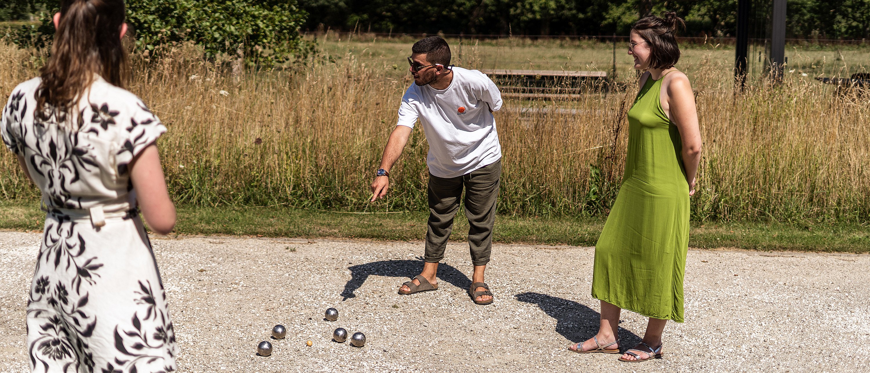 Die Spieler konzentrieren sich während einer Pétanque-Runde auf das Spielfeld und entscheiden, ob sie eine Kugel in der Nähe des Spieles platzieren oder die gegnerische Kugel treffen sollen.