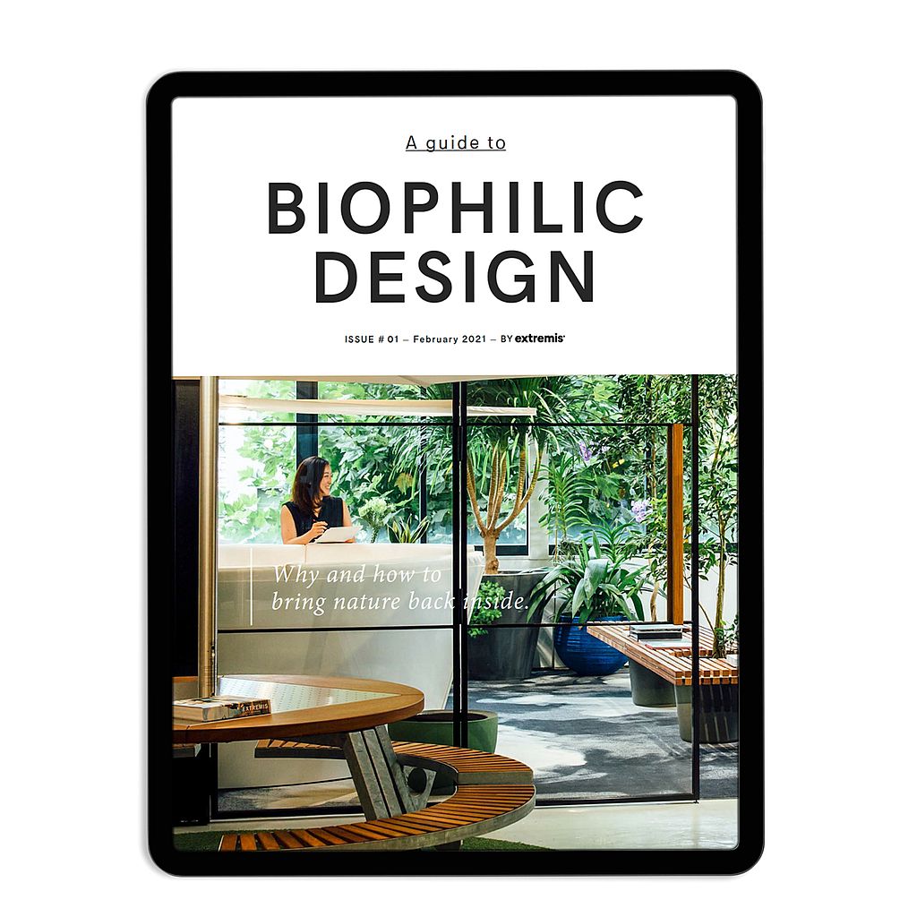 Tablet mockup met de omslag van A guide to Biophilic Design, met een weelderige binnen-buiten scene vol planten zichtbaar door glazen deuren en ronde houten meubels op de voorgrond.