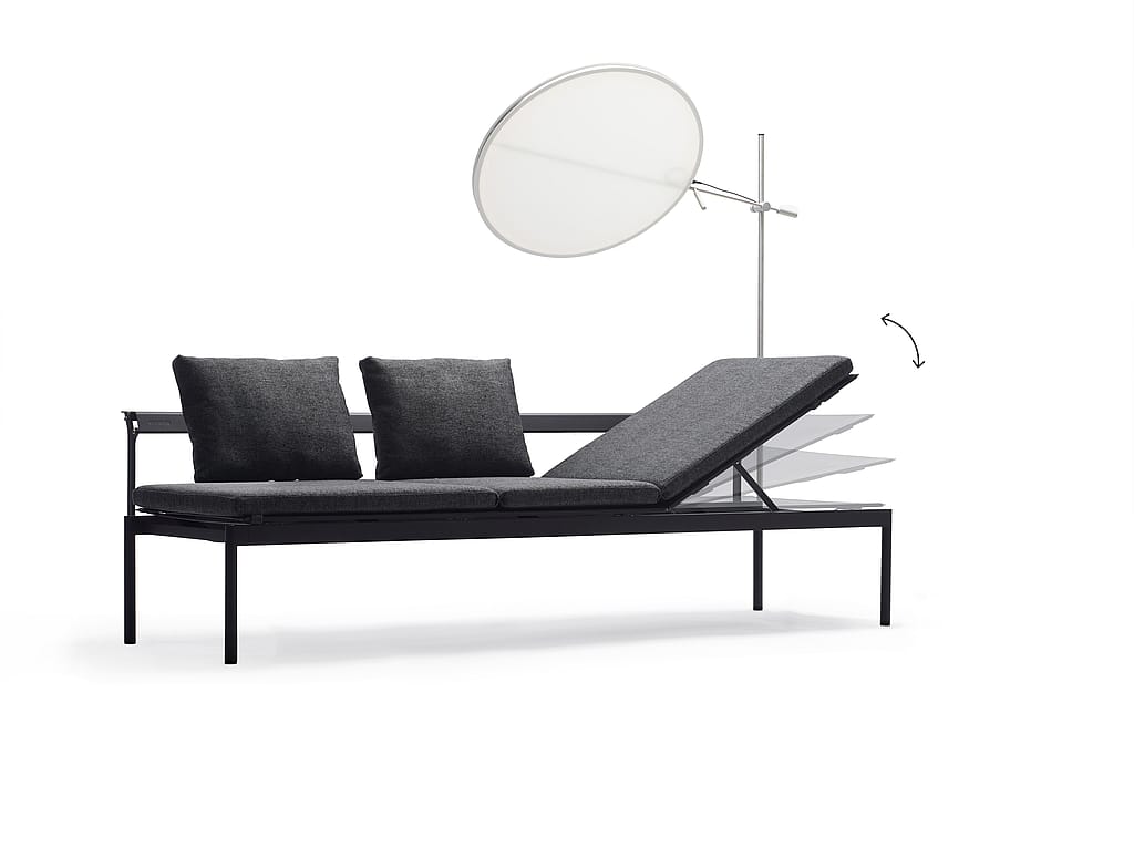 Donkergrijze Sol+Luna loungebank met twee kussens, een verstelbare rugleuning en een rond wit zonnescherm op een effen studioachtergrond.