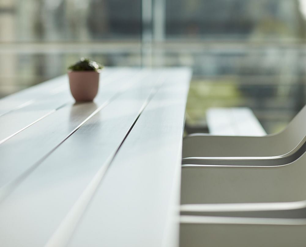 Close-up of the coated fiberglass surface used on Marina tables, highlighting a smooth, wood-like finish in a light color.