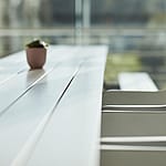 Close-up of the coated fiberglass surface used on Marina tables, highlighting a smooth, wood-like finish in a light color.