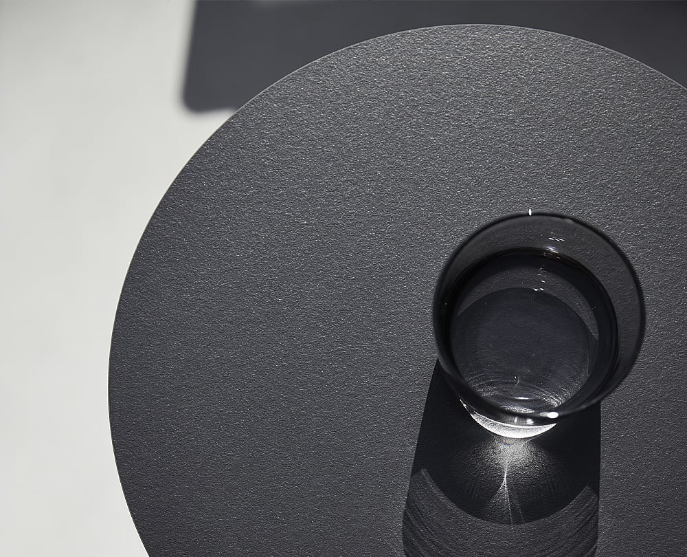 Close-up of an HPL tabletop surface, highlighting the smooth, durable finish used on Extremis outdoor furniture.