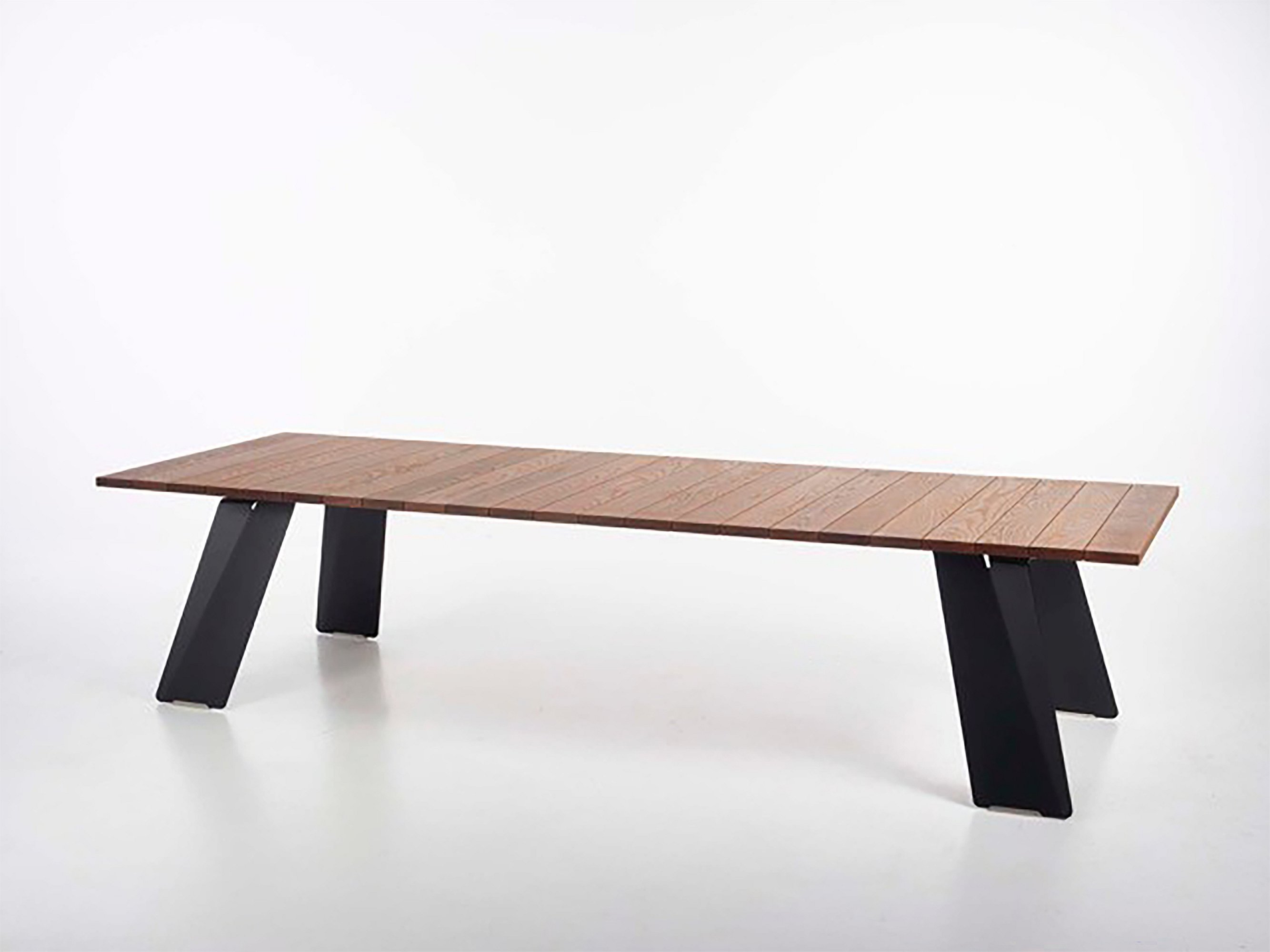 Studio shot of a long rectangular wooden Pontsun table with white angled legs on a plain white background.