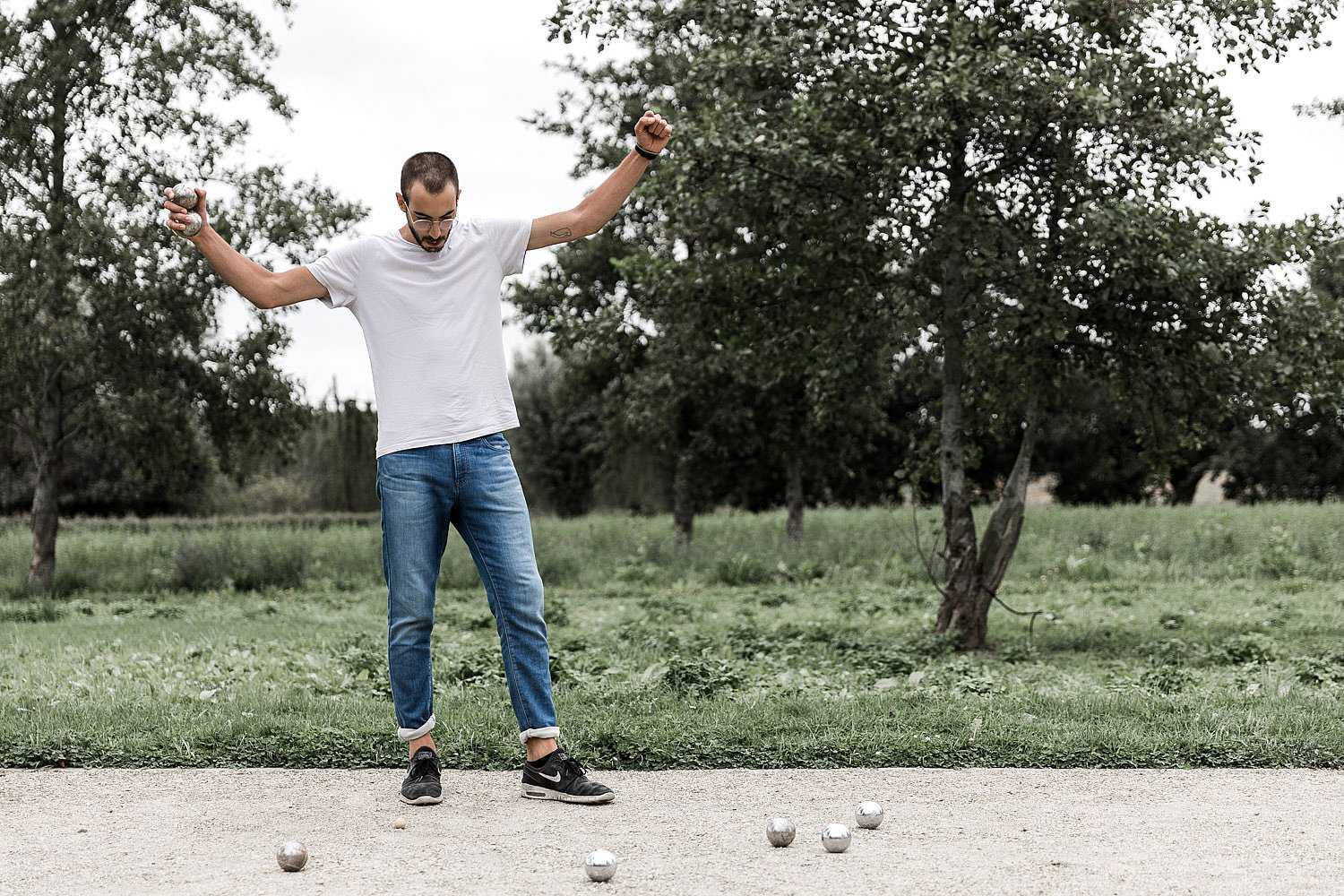 Man viert tijdens een jeu de boules spel op een buitenveld op de Extremis campus.