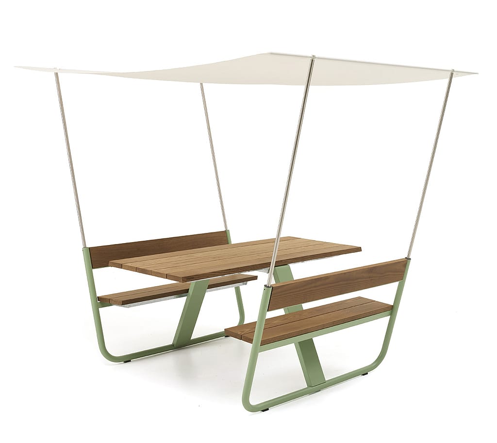 Vue de style studio de la table de pique-nique Manille avec plateau et bancs en bois, cadre vert pâle et une simple toile tendue fixée aux dossiers.
