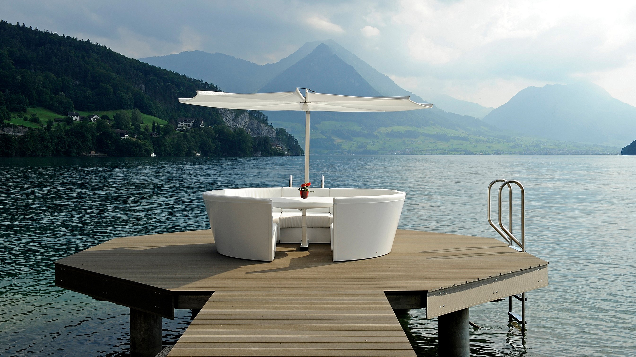 Kosmos runde Outdoor-Lounge mit integriertem Tisch und rundem Schatten, präsentiert als gemütlicher All-in-One-Raum zum Reden, Essen, Entspannen und Faulenzen.