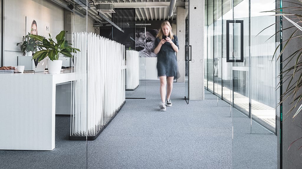 Stickt das Heldenbild des Raumteilers auf und führt einen biophilen Teiler aus vertikalen Stäben ein, der Privatsphäre schafft und gleichzeitig einen offenen Fluss aufrechterhält.