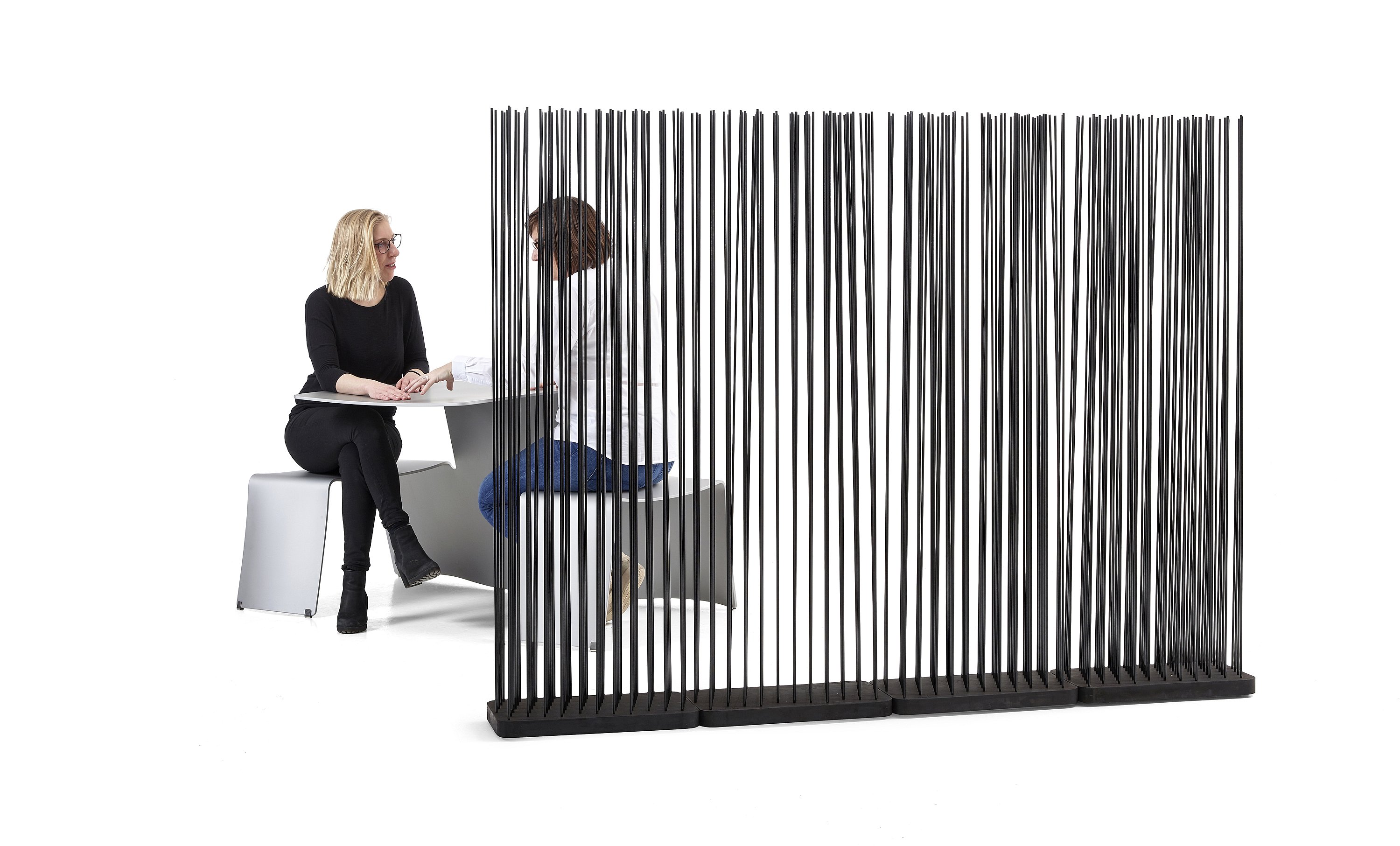 Stick-divider, l’image du héros présentant un séparateur biophilique composé de tiges verticales qui crée de l’intimité tout en gardant une circulation ouverte.