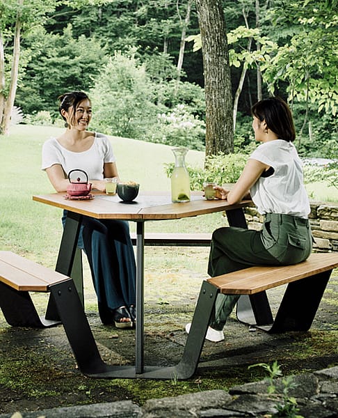 Compacte Anker picknicktafel met zes zitplaatsen, houten tafelblad en banken, op een lichte achtergrond.
