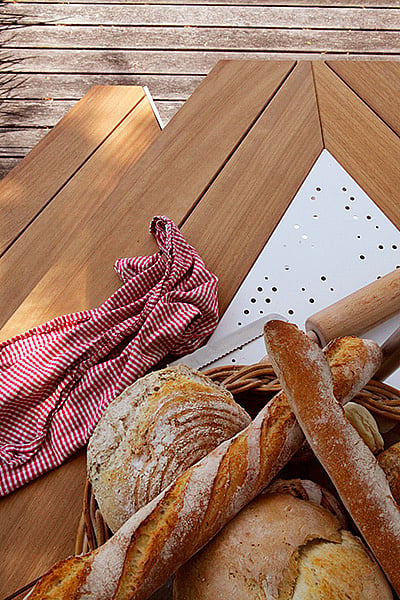 Nahaufnahme von frischem Brot, einem rot karierten Tuch und einem Nudelholz auf der hölzernen Anker Tischplatte