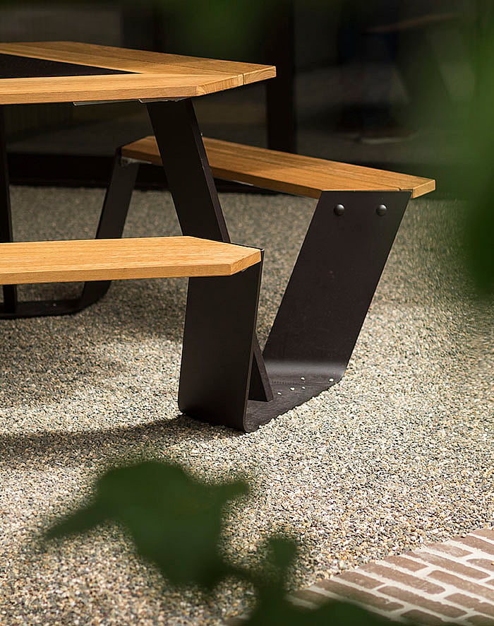 Houten Anker tafel met zwart stalen frame naast de fontein op de binnenplaats van de brouwerij Vanhonsebrouck