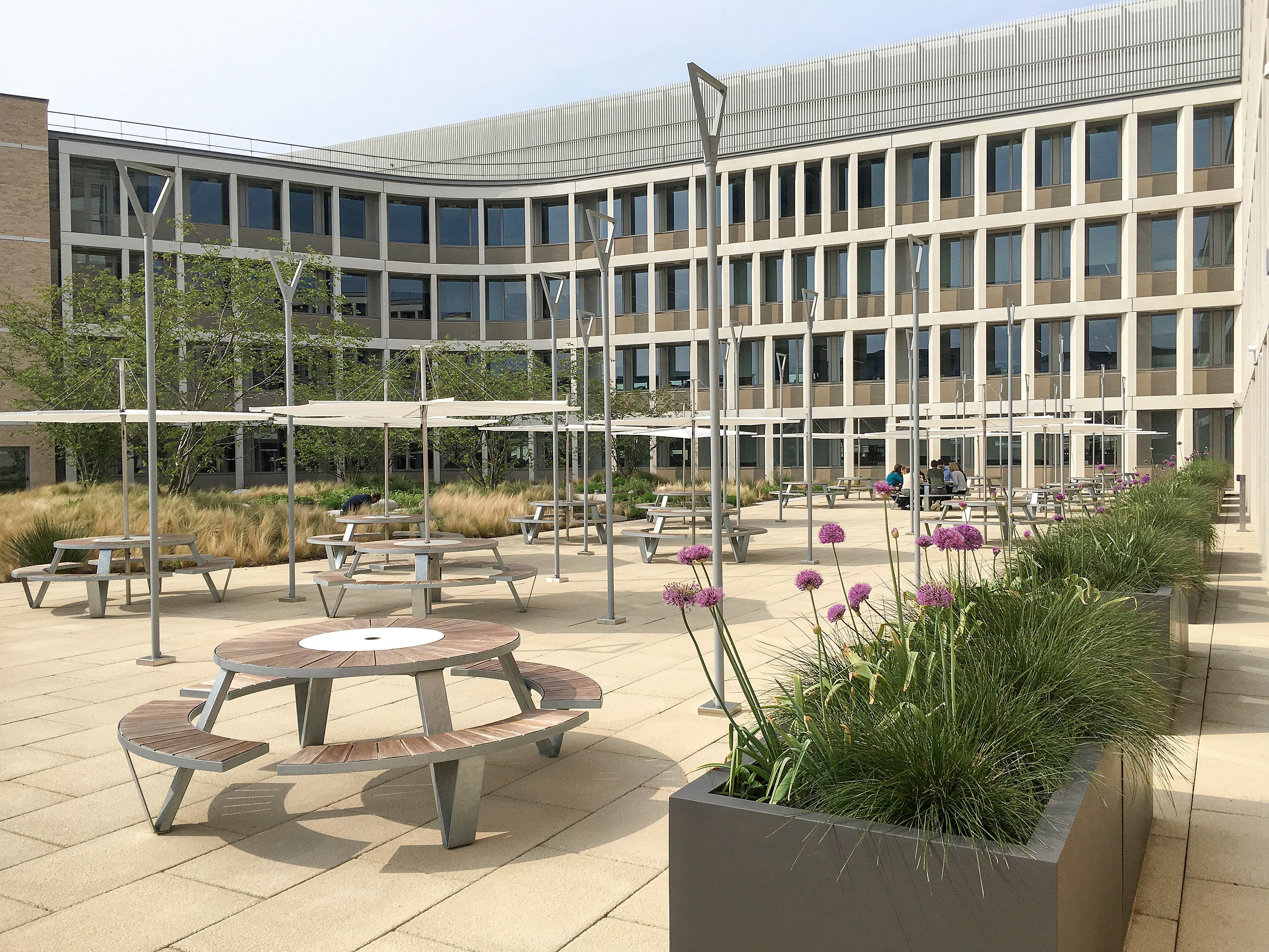 Pantagruel picnic tables with Inumbrina parasols in the Cambridge Assessment courtyard