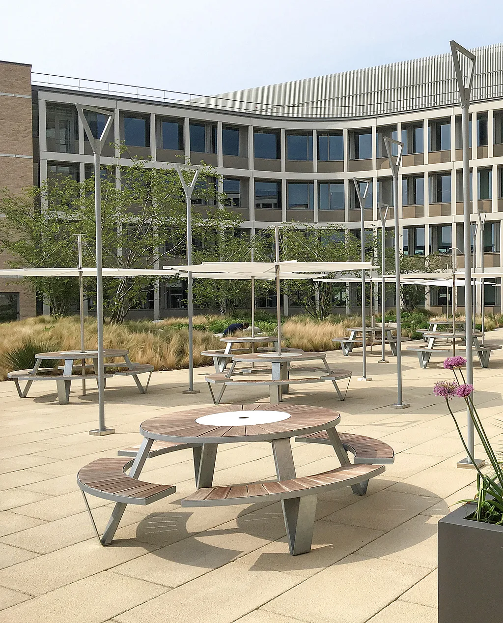 Pantagruel picknicktafels met Inumbrina-parasols op de binnenplaats van Cambridge Assessment