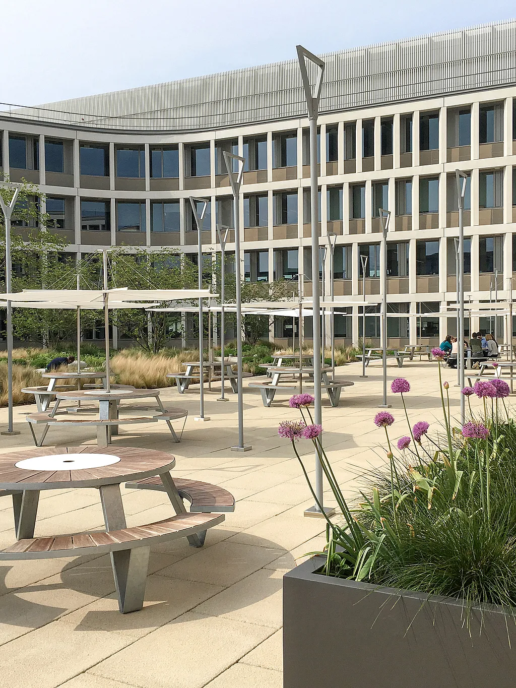 Pantagruel picnic tables with Inumbrina parasols in the Cambridge Assessment courtyard