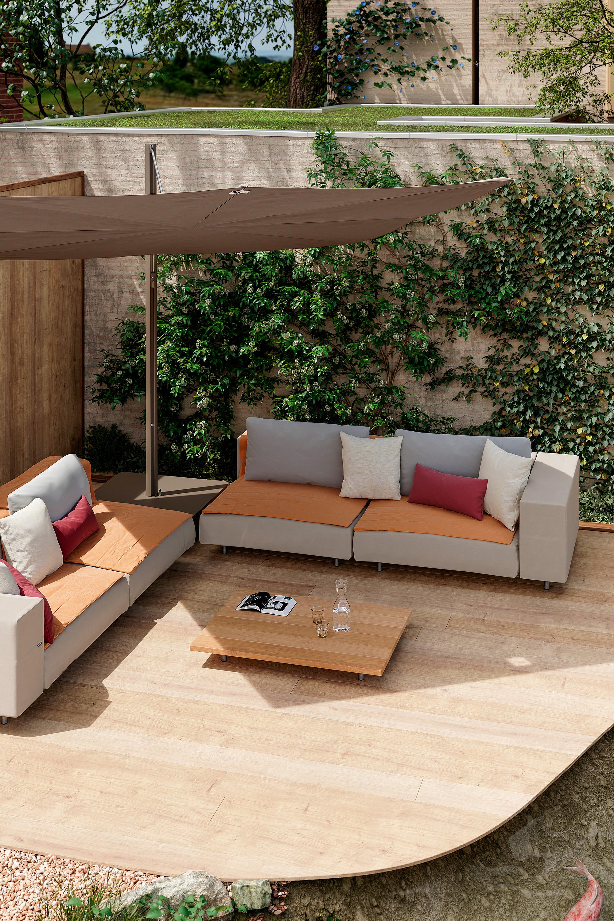 Walrus sofa with orange cushions and pillows under a taupe Sensu shade on a sheltered garden patio