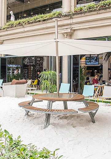 Table ronde Gargantua avec abat-jour intégré Inumbra sur une terrasse de café sablonneuse à Shanghai