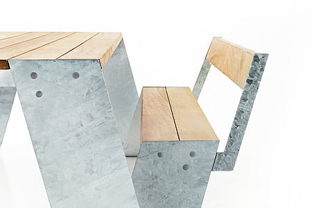 Close-up van een Extremis Hopper picknicktafel met gegalvaniseerde stalen poten en een houten tafelblad en bank met rugleuning.