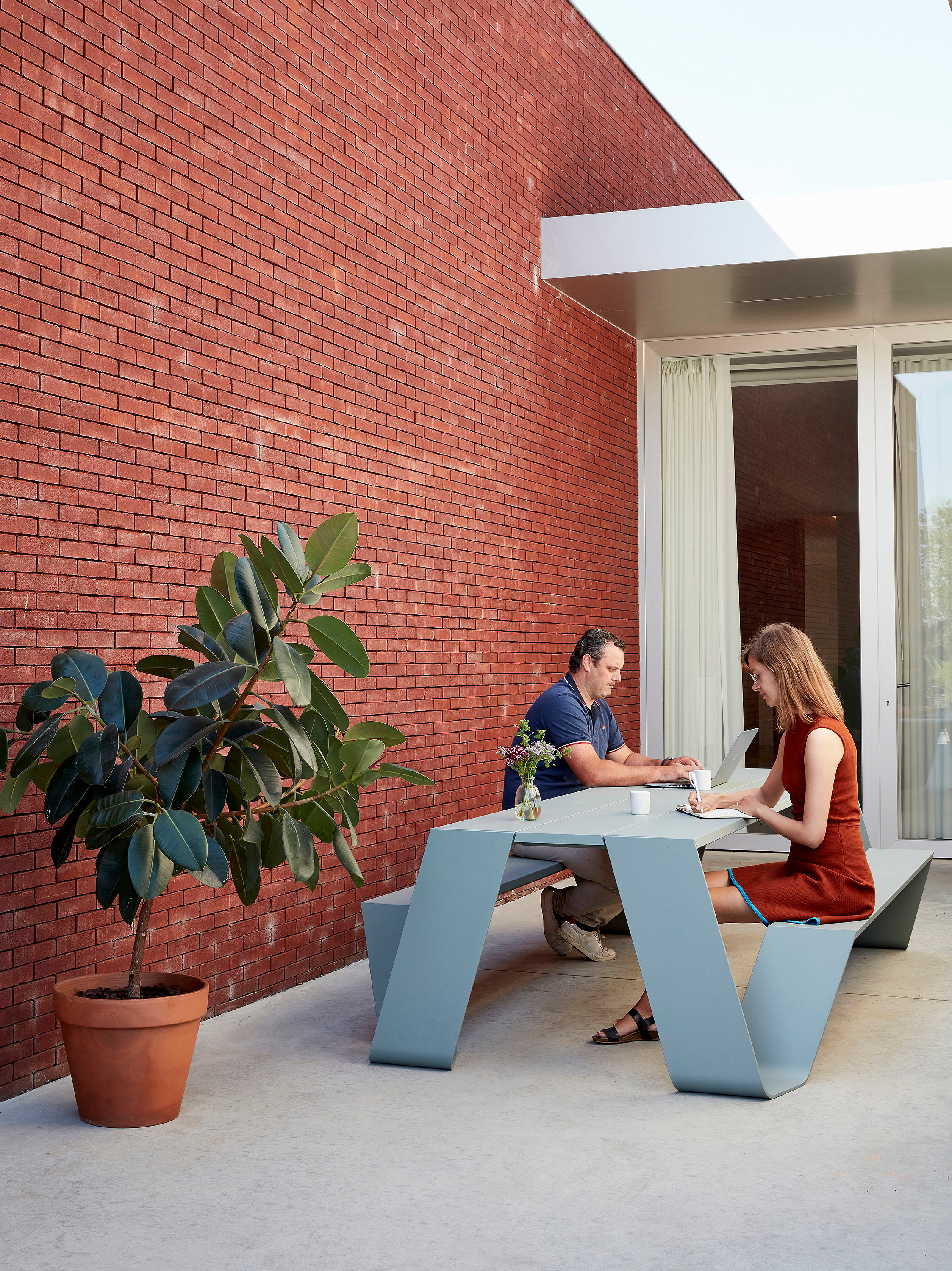 Table de pique-nique Extremis Hopper tout aluminium coloris vert-de-gris, avec deux personnes qui y travaillent