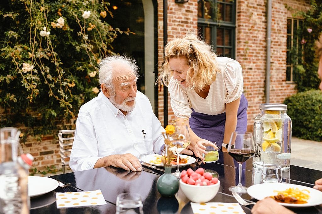 People enjoying lunch around a Panigiri Lava table on a sunny terrace