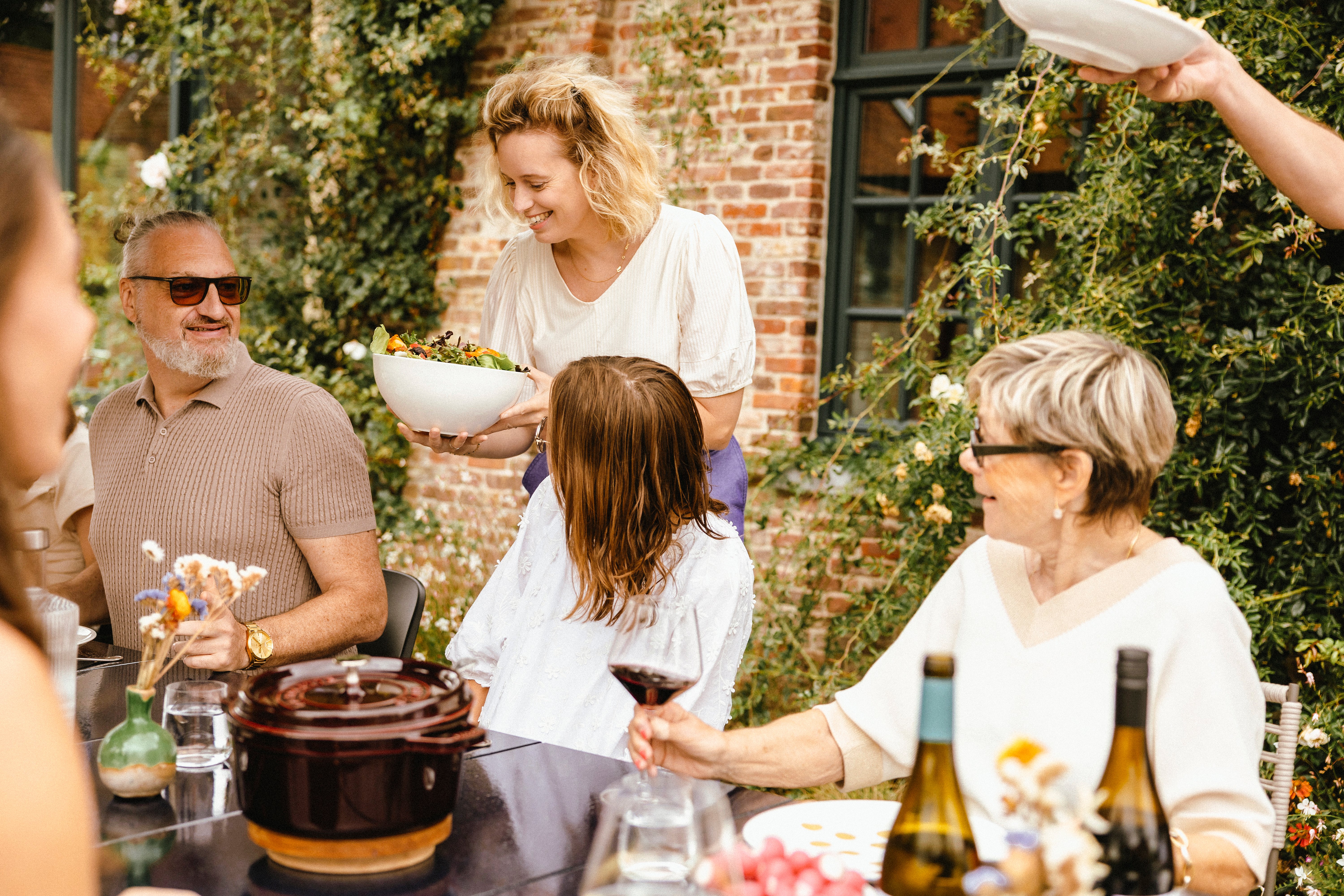 Family gathered around a Panigiri Lava table with Captain’s Chairs outdoors