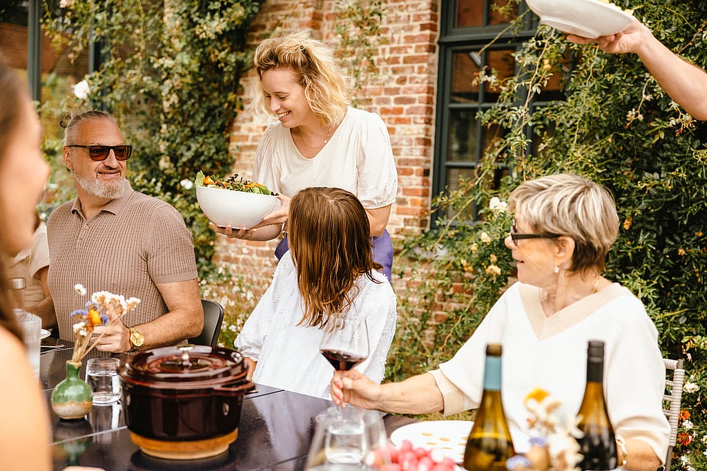 Family gathered around a Panigiri Lava table with Captain’s Chairs outdoors
