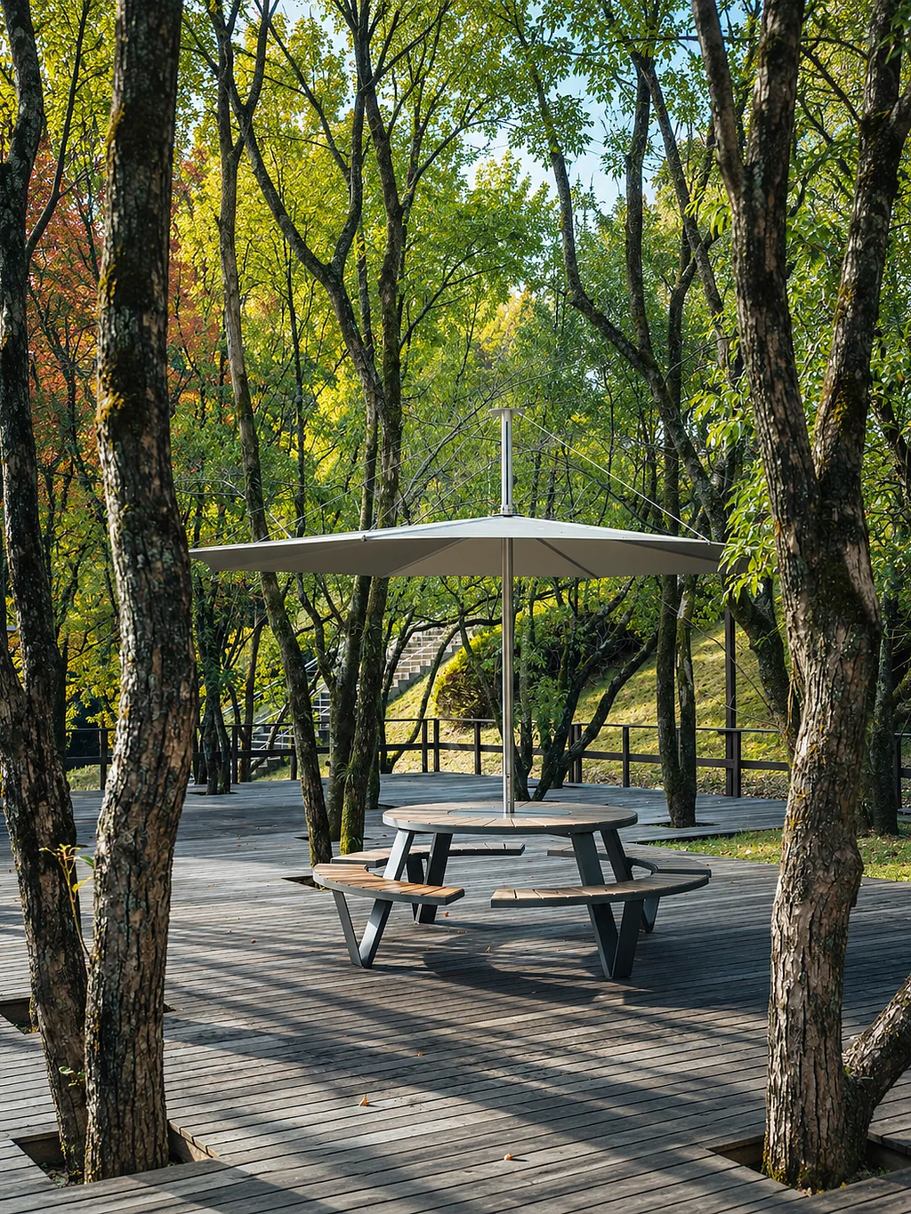 Pantagruel picnic table with integrated benches and central shade on a wooden deck in a wooded setting.