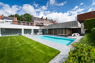 Modern city courtyard with swimming pool, green lawn and Extremis outdoor furniture