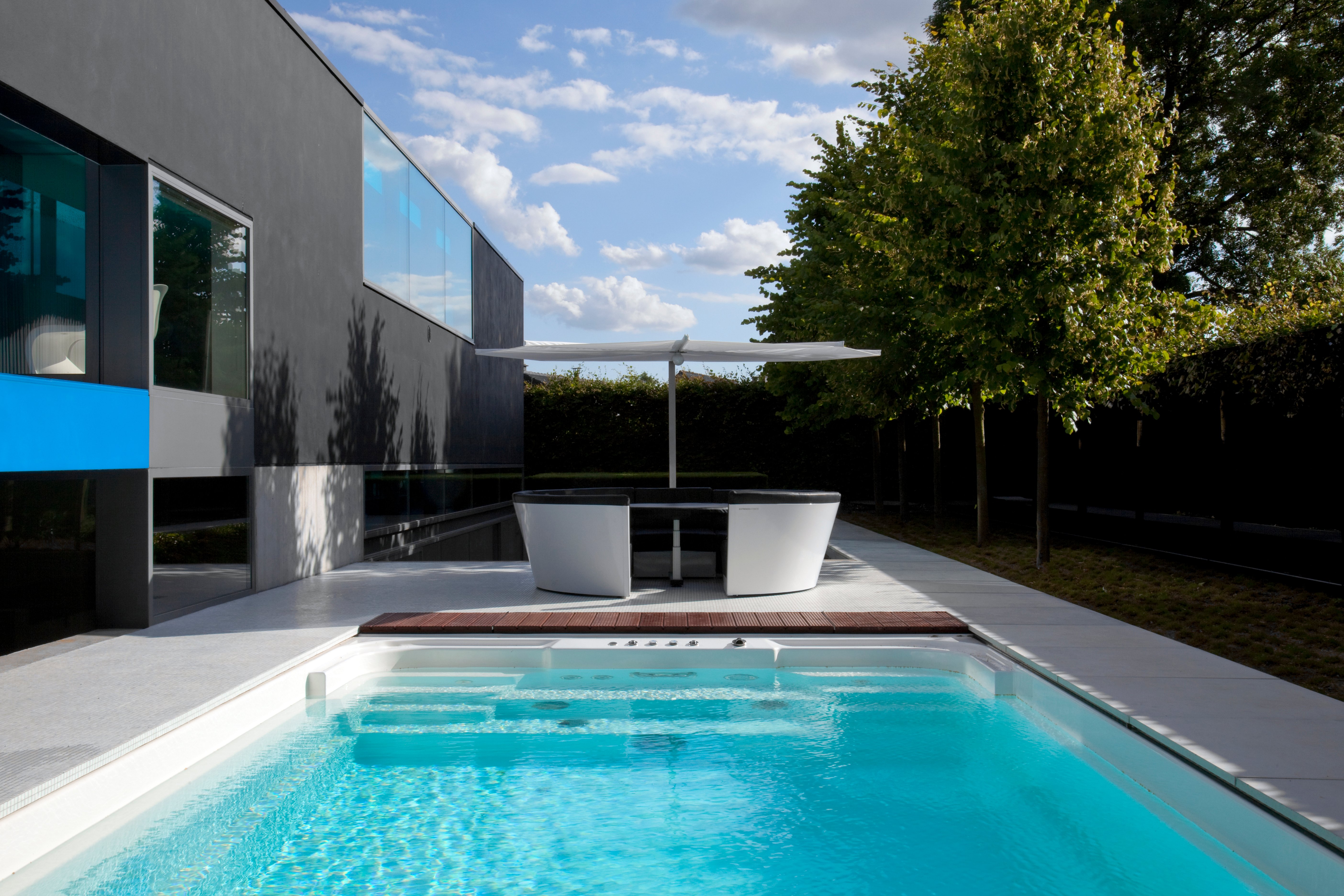 Maison noire moderne avec piscine et mobilier d'extérieur Extremis sur la terrasse
