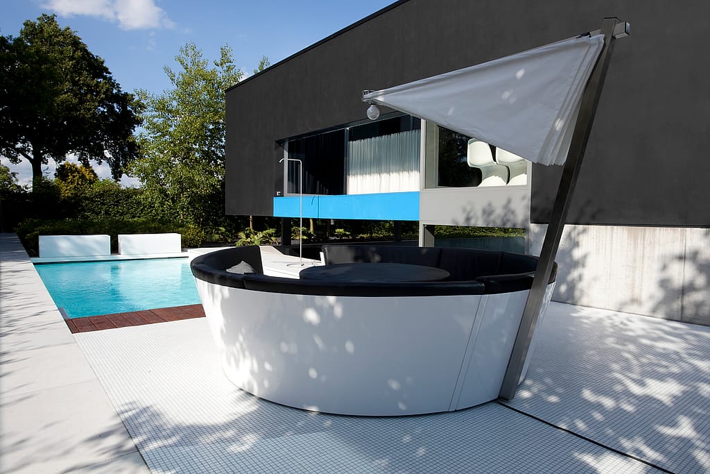 Canapé circulaire Kosmos avec ombrage intégré au bord d'une piscine moderne