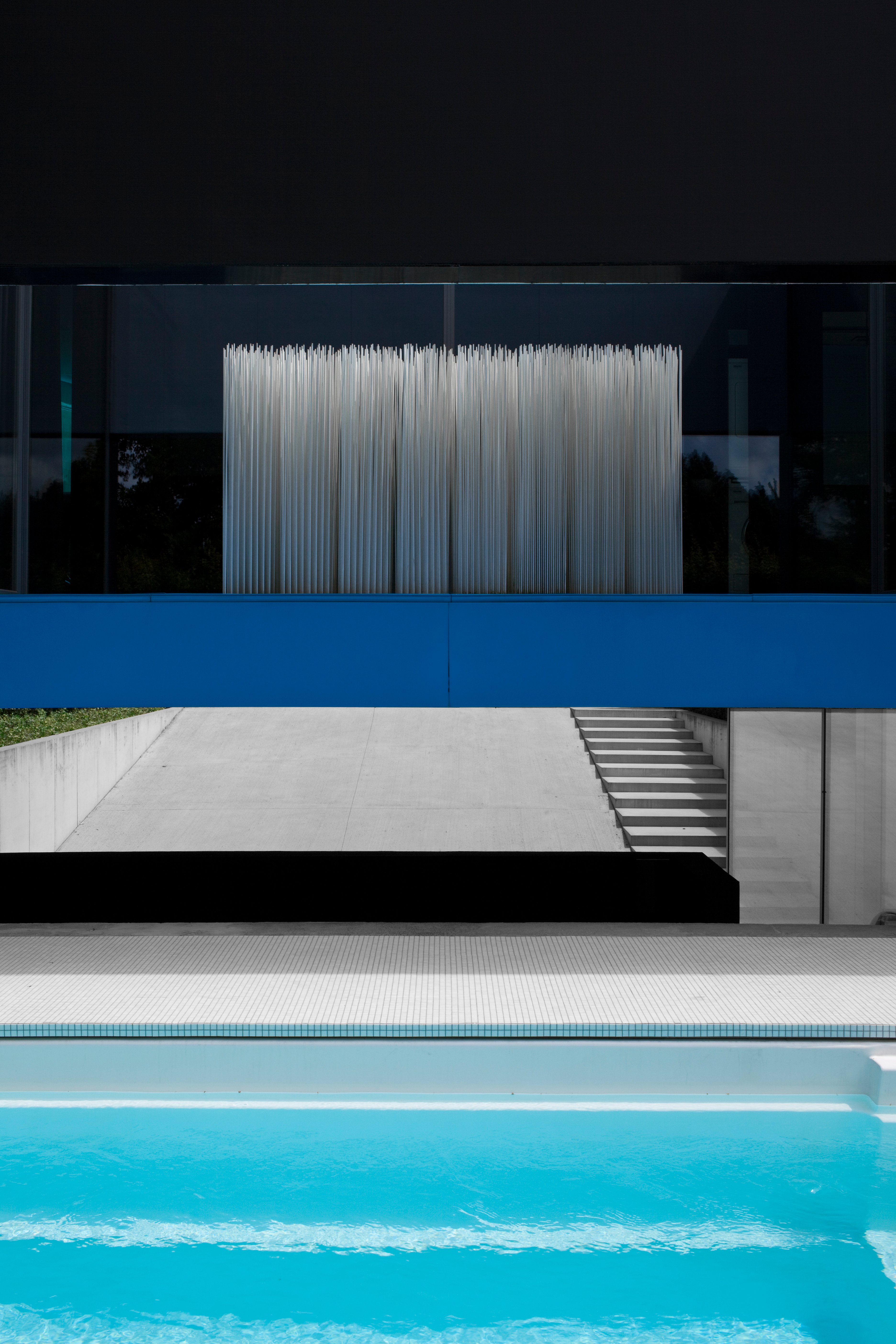 Façade noire minimaliste reflétée dans la piscine