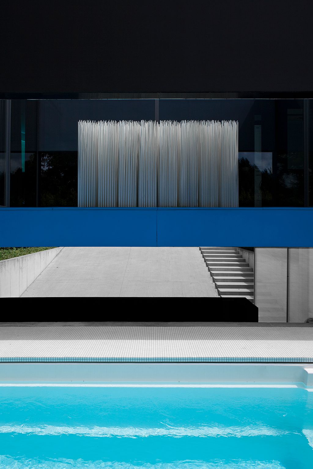 Façade noire minimaliste reflétée dans la piscine