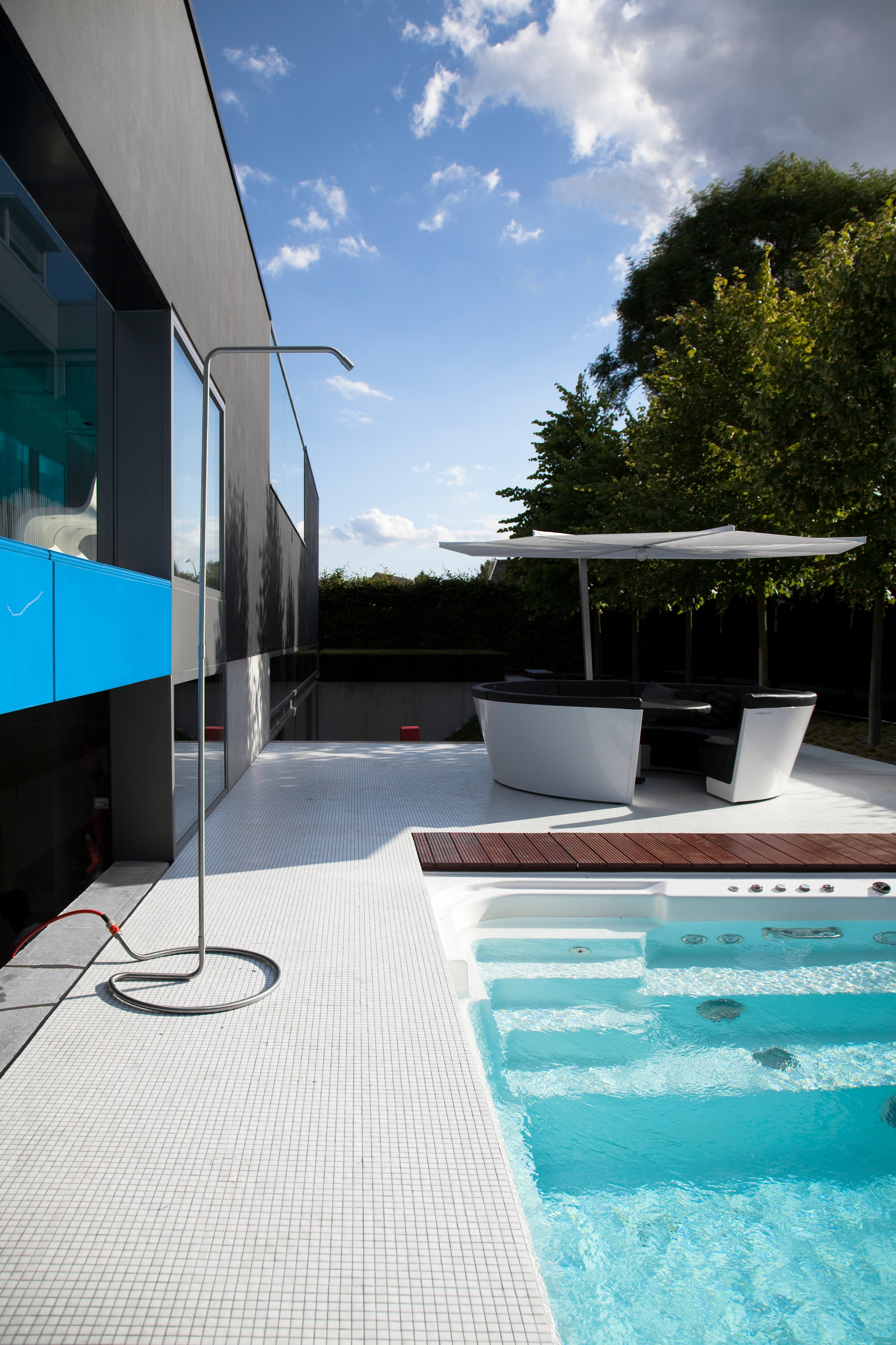 Terrasse de piscine avec architecture moderne et assises ombragées
