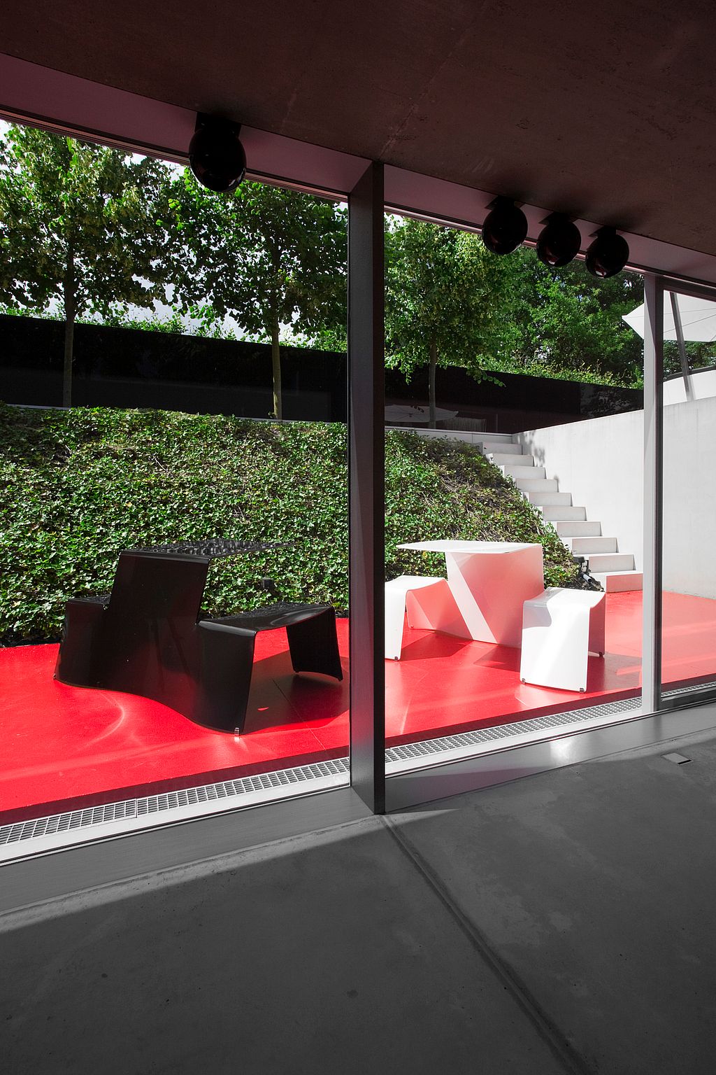 Assises sur une terrasse rouge le long de la maison moderne