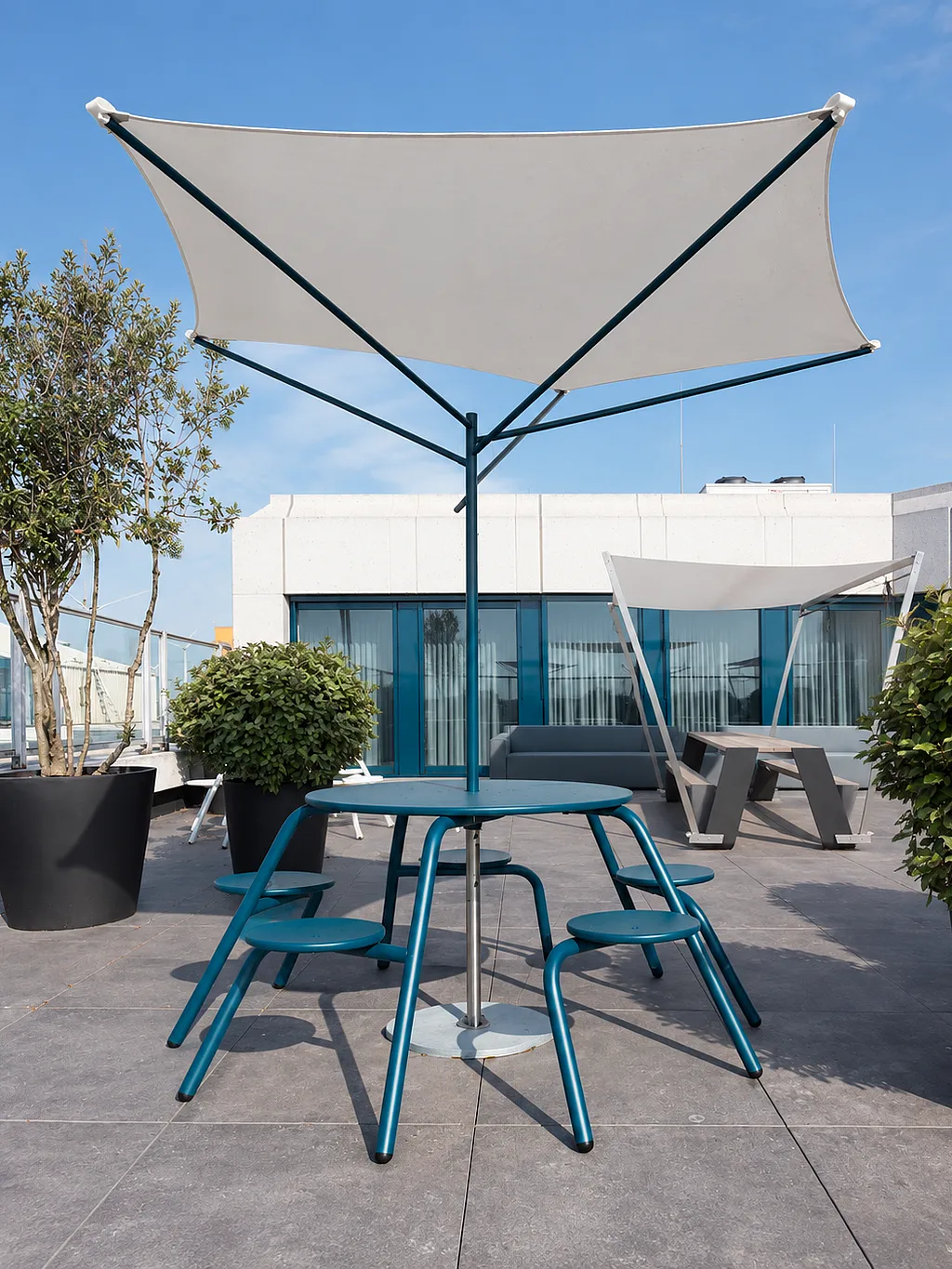 Table Virus bleue avec parasol Acacia sur un toit-terrasse de bureau moderne