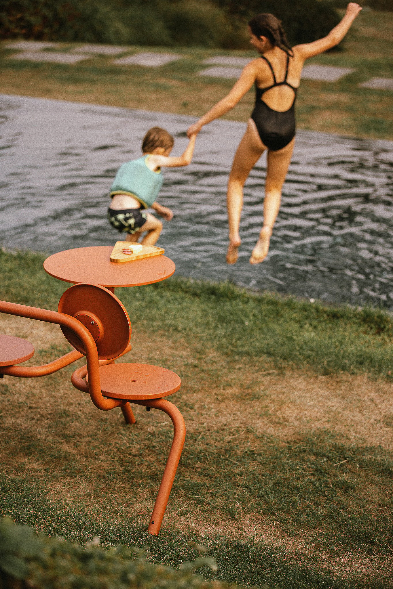 Bistroo seat beside the pool as children jump into the water