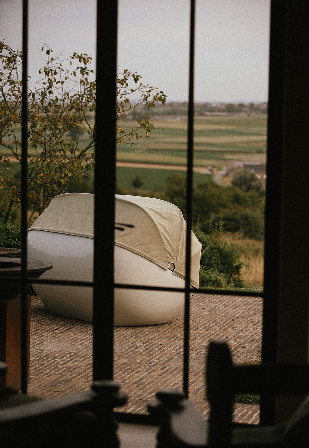 Geschlossenes Cabrio-Gartensofa auf einer Terrasse mit Blick auf die Landschaft