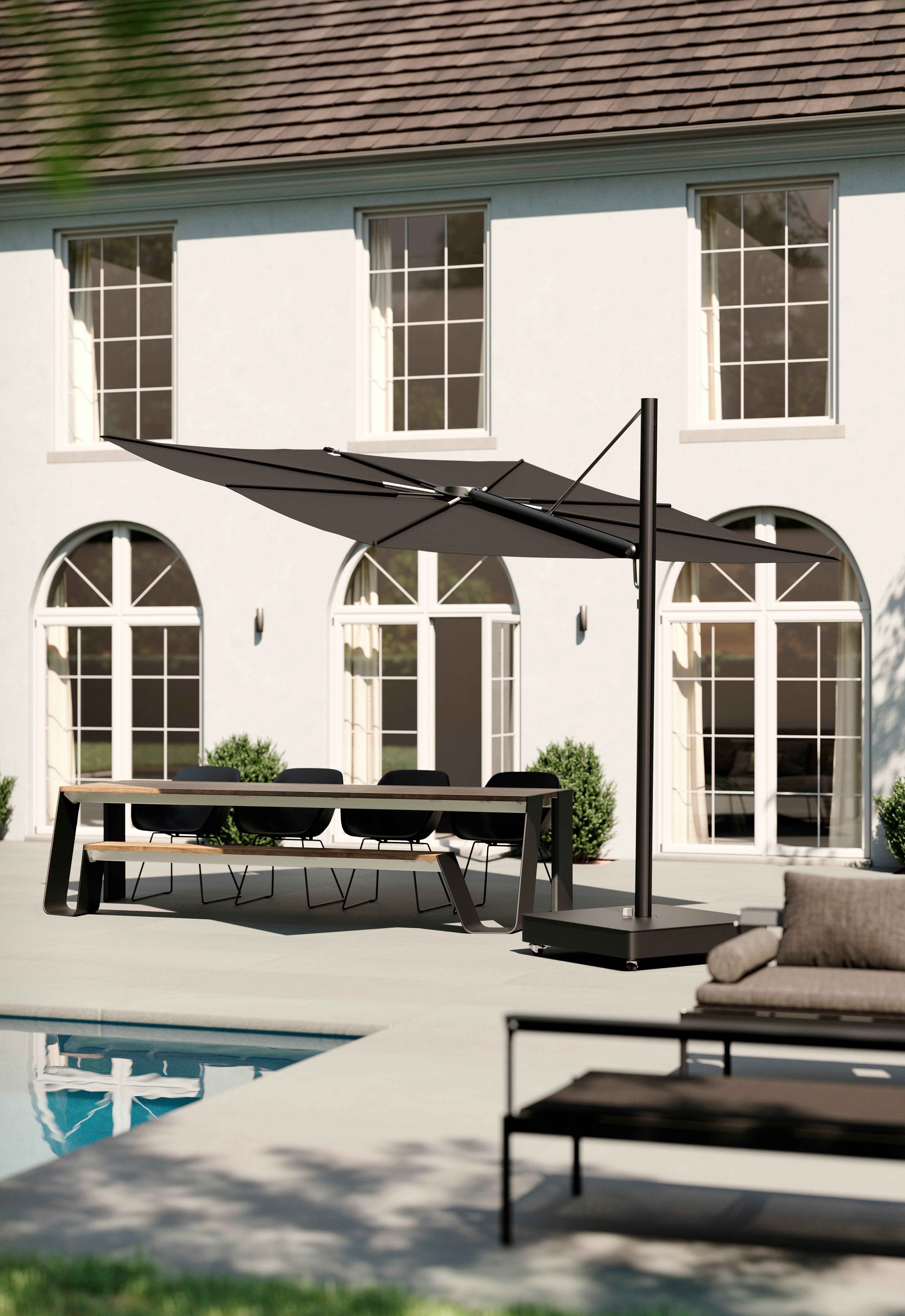 Schwarzer Sensu Sonnenschirm beschattet einen Esstisch auf einer Poolterrasse neben einer weißen Villa.